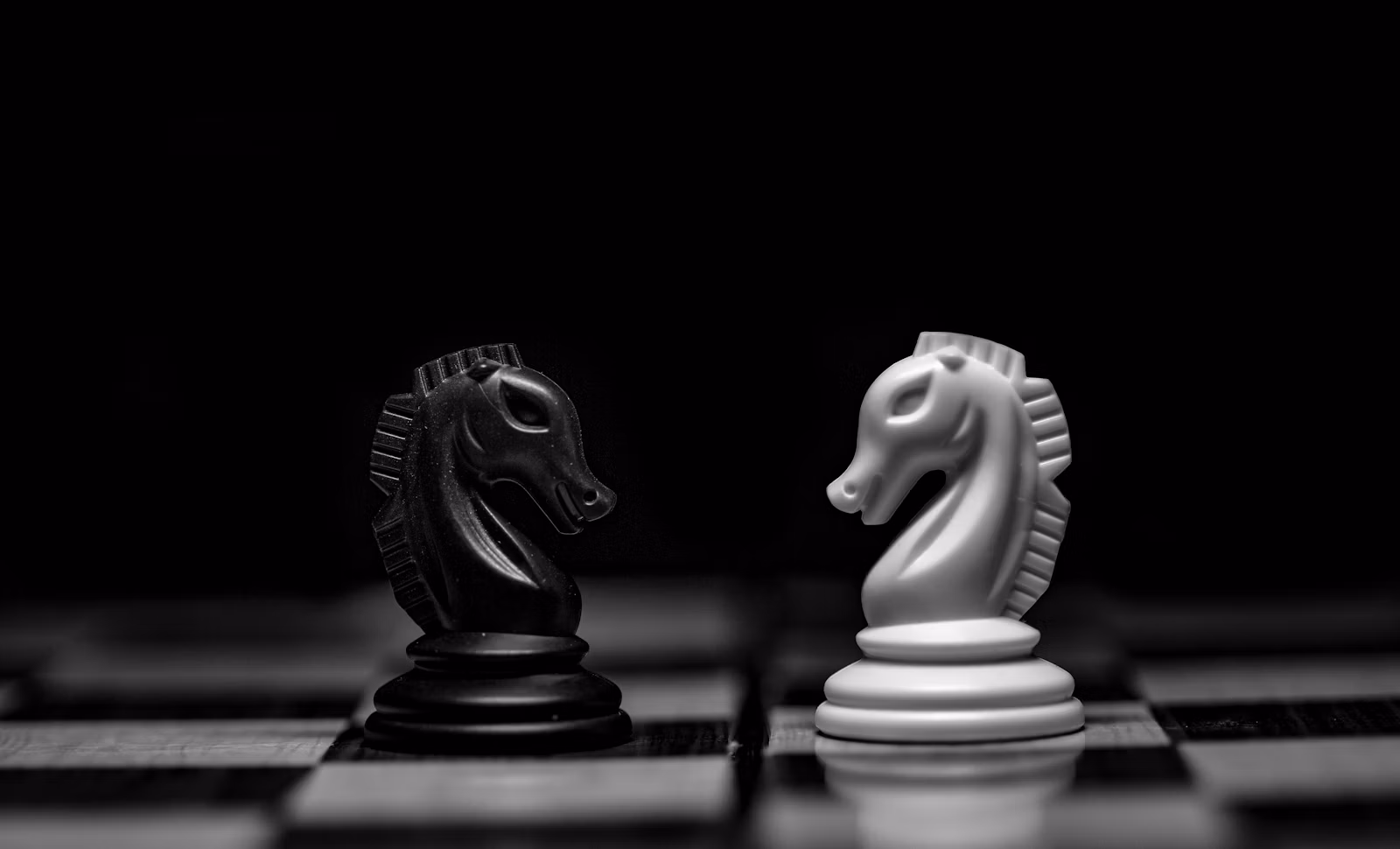 Chess knights facing each other representing attackers and defenders